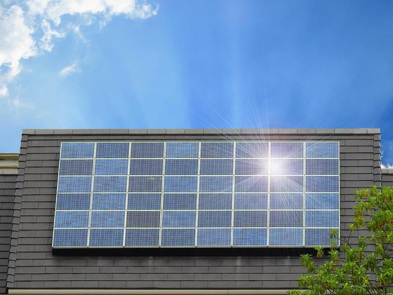 Green energy of solar cell panel on house roof in blue sky and sunlight